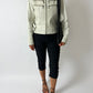 Person wearing a light-colored leather jacket and black pants on a white background