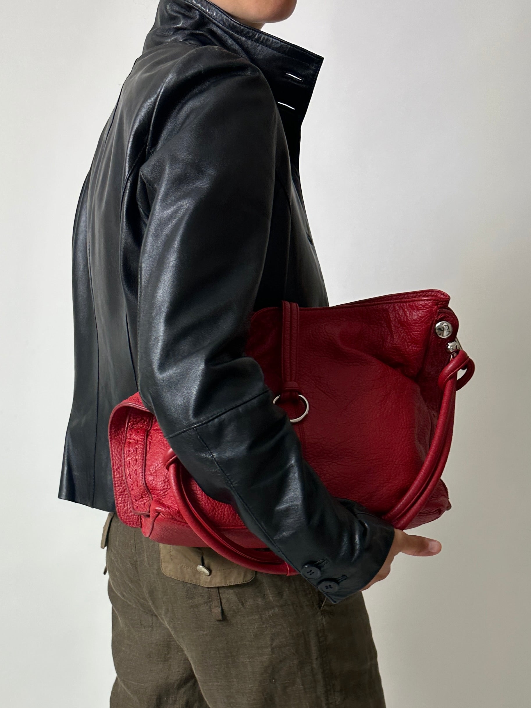 Vintage leather fitted jacket with funnel neck worn with a leather shoulder bag in bright red with silver ring detail. Timeless vintage outfit 